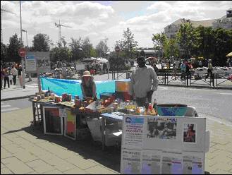 Brocante juin 2005 : Bernadette (responsable Aumônerie) et Théophile : Vente de produits et campagne sur les Objectifs du Millénaire pour le Développement